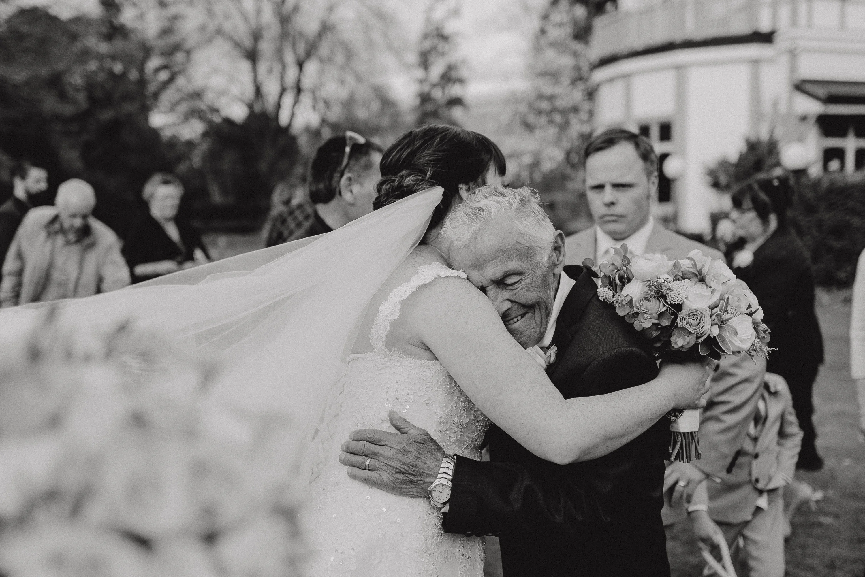 beautiful wedding photo of bride hugging her grandad after the ceremony