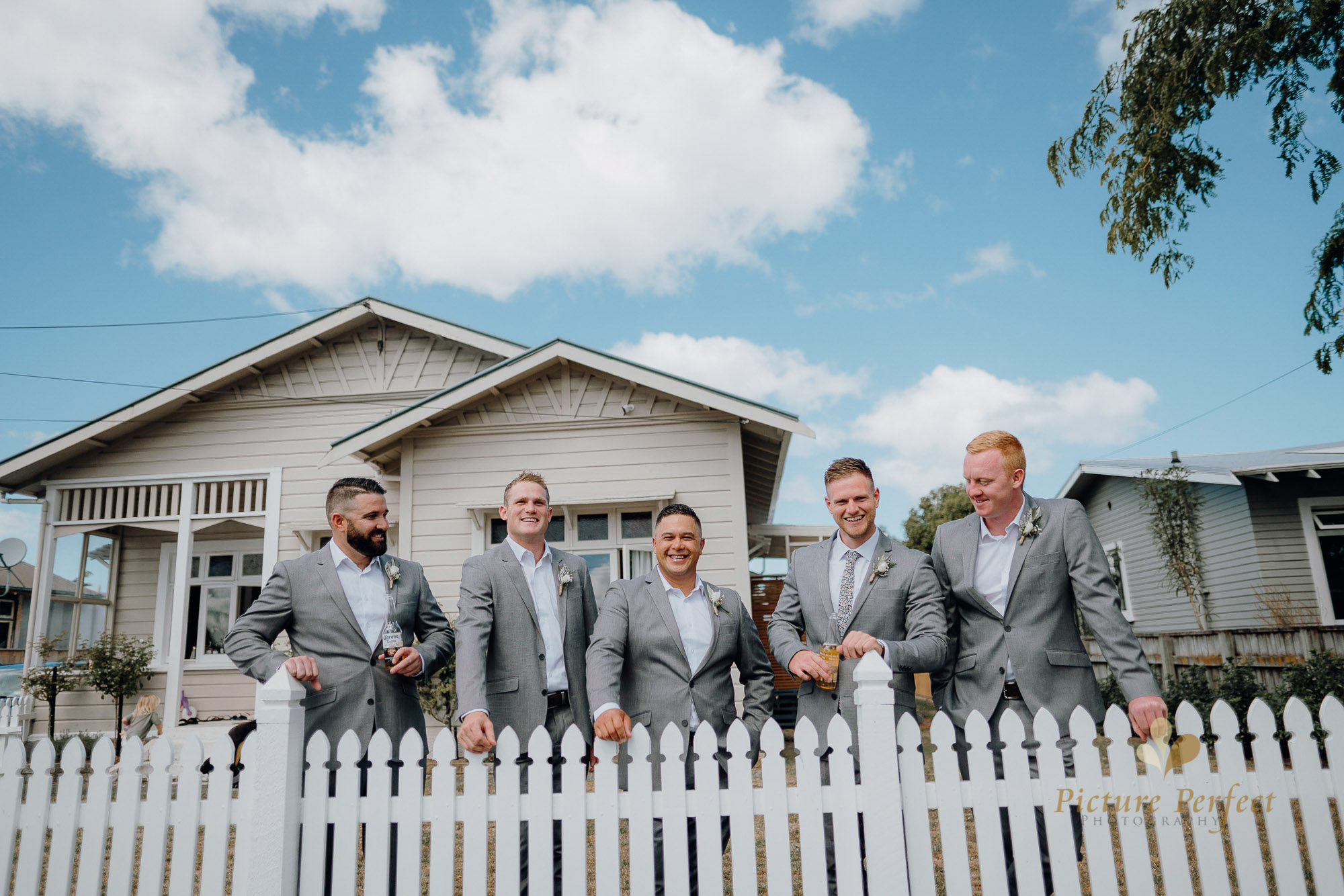 Kyle and boys posing for their Whanganui wedding photo outside his home