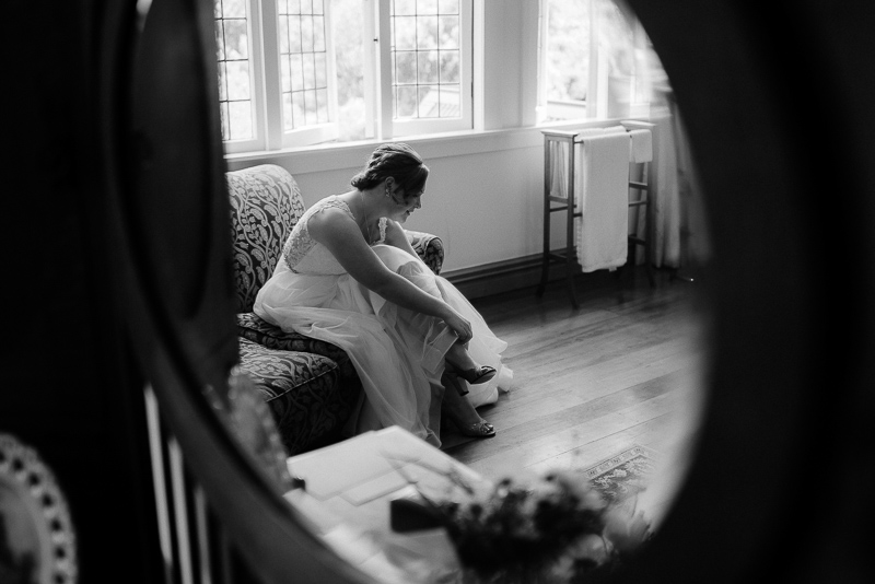bride getting changed via a mirror reflection in black and white