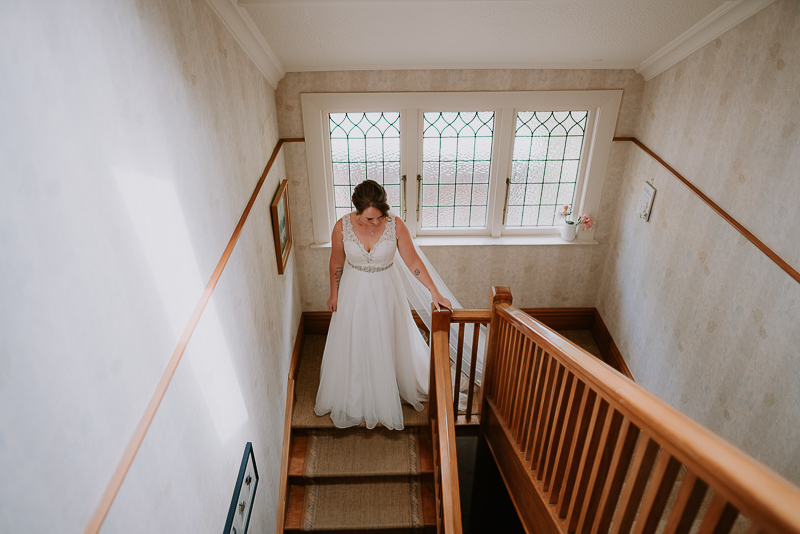 bride walking down stair on her wedding film at Roseburn Park